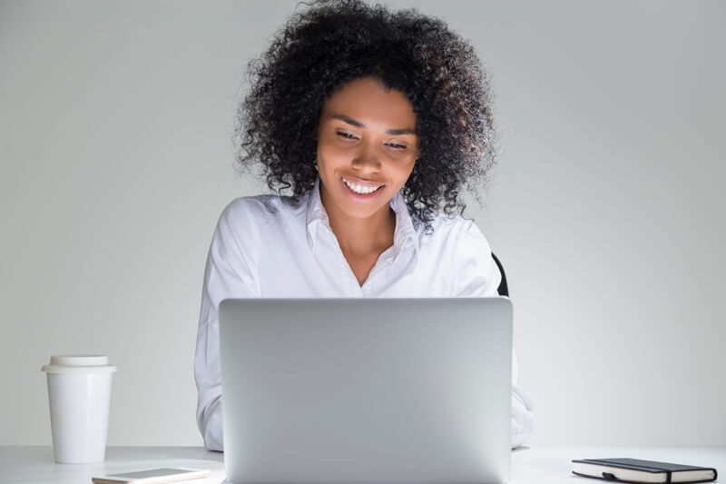 Happy woman taking a webinar on her computer